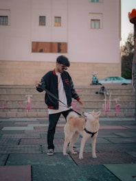 Close-up of a durable, minimalist leash held by a young urban pet owner on a city street.