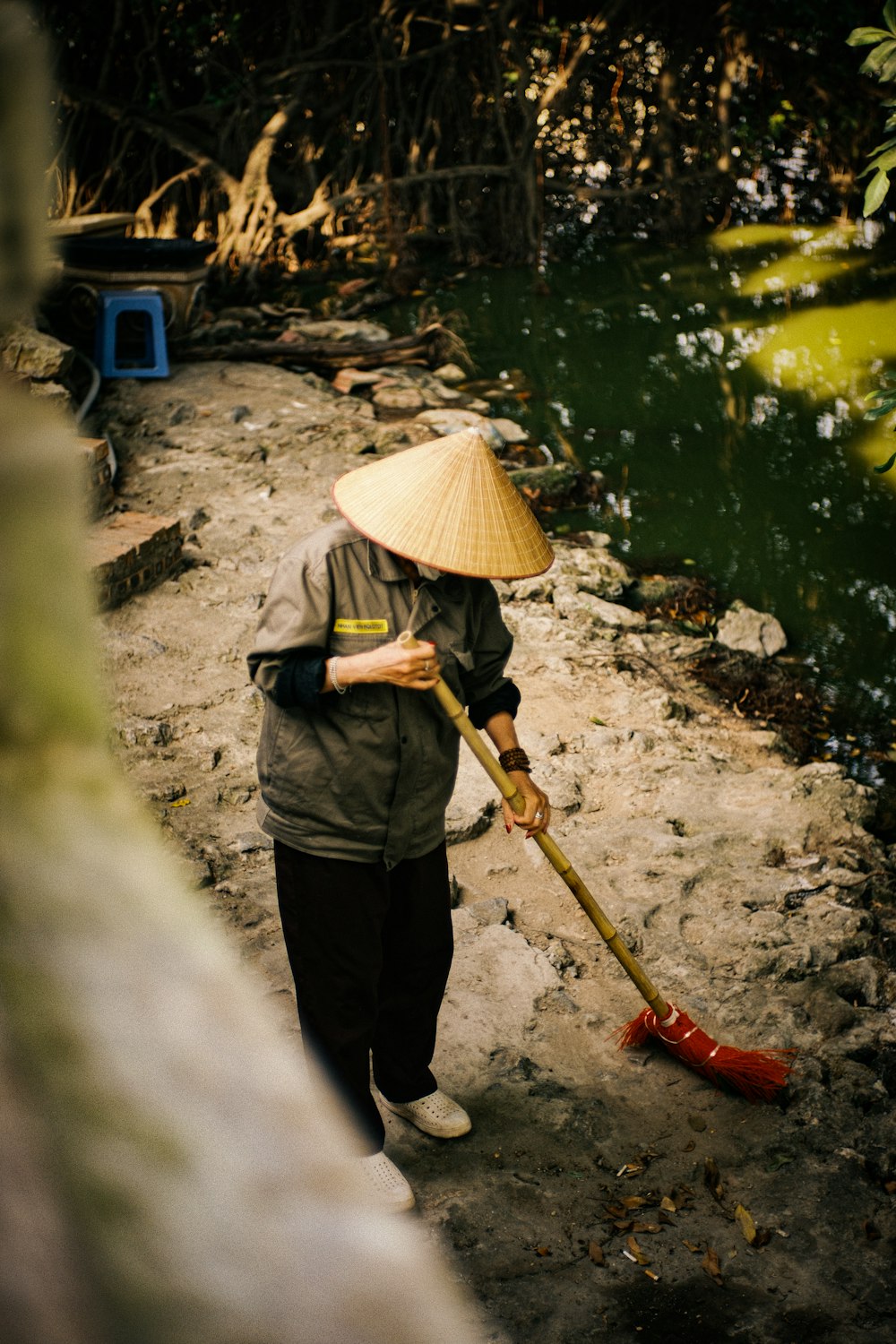 a woman with a straw hat is holding a shovel
