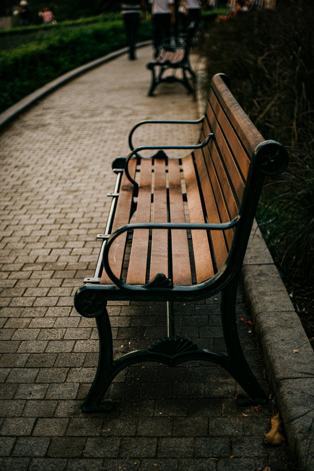 a wooden bench sitting on top of a brick walkway