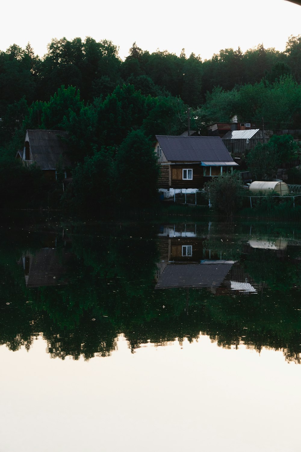 a lake with houses and trees in the background