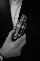 Monochrome photo of a stylish man applying cologne, embodying elegance and masculinity.