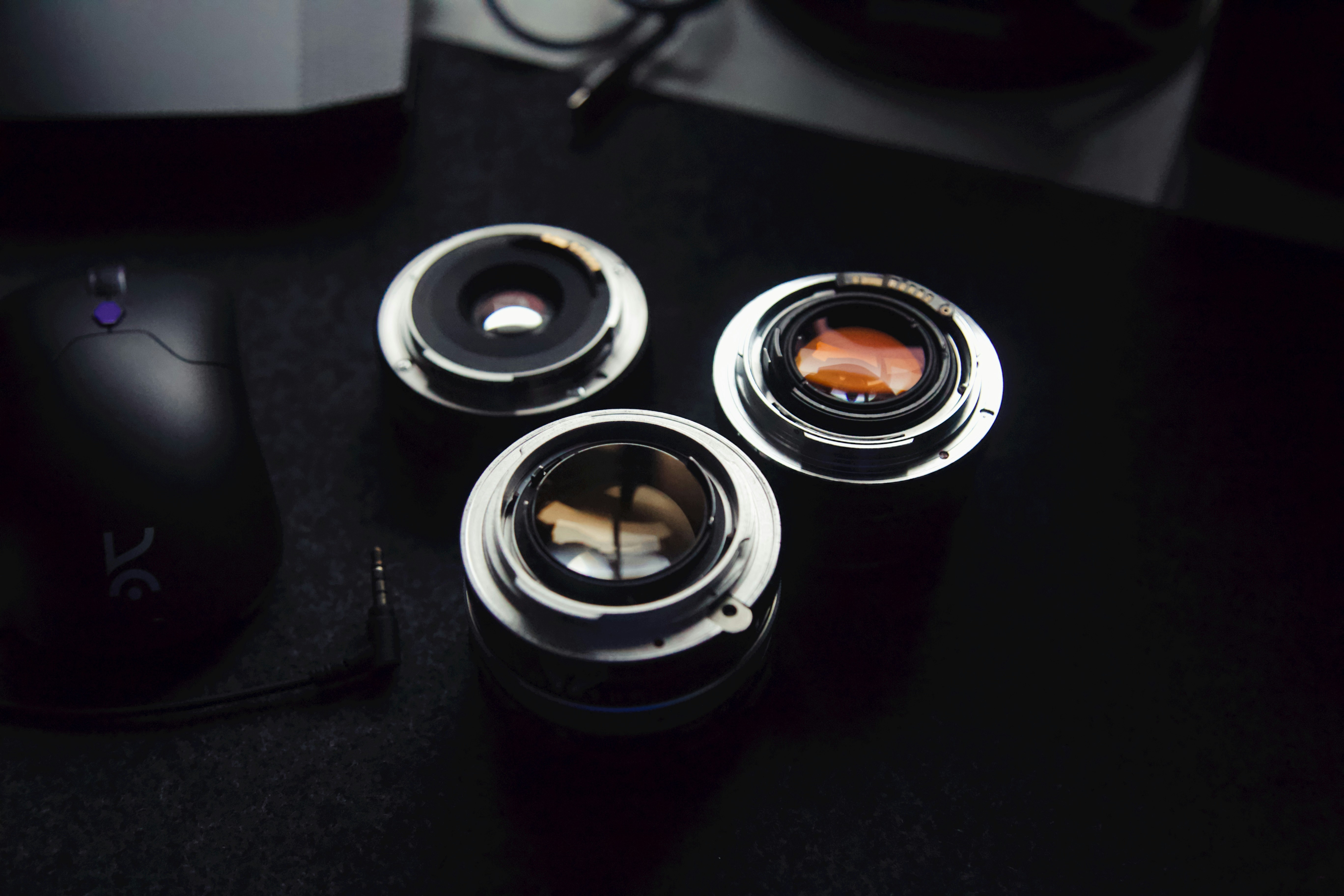 three cameras sitting on top of a table next to a mouse