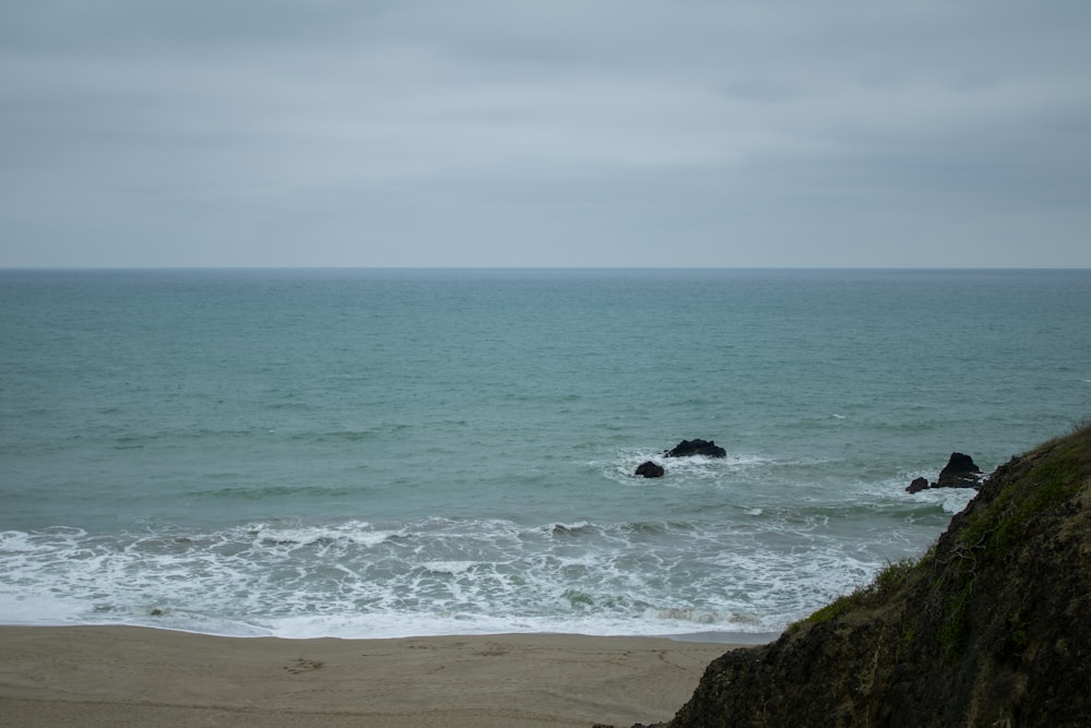 a body of water sitting next to a rocky cliff