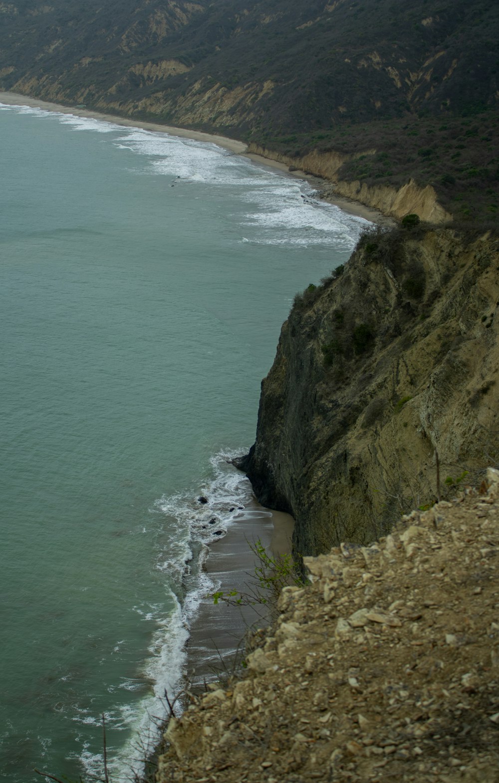 une grande étendue d’eau assise à côté d’une falaise