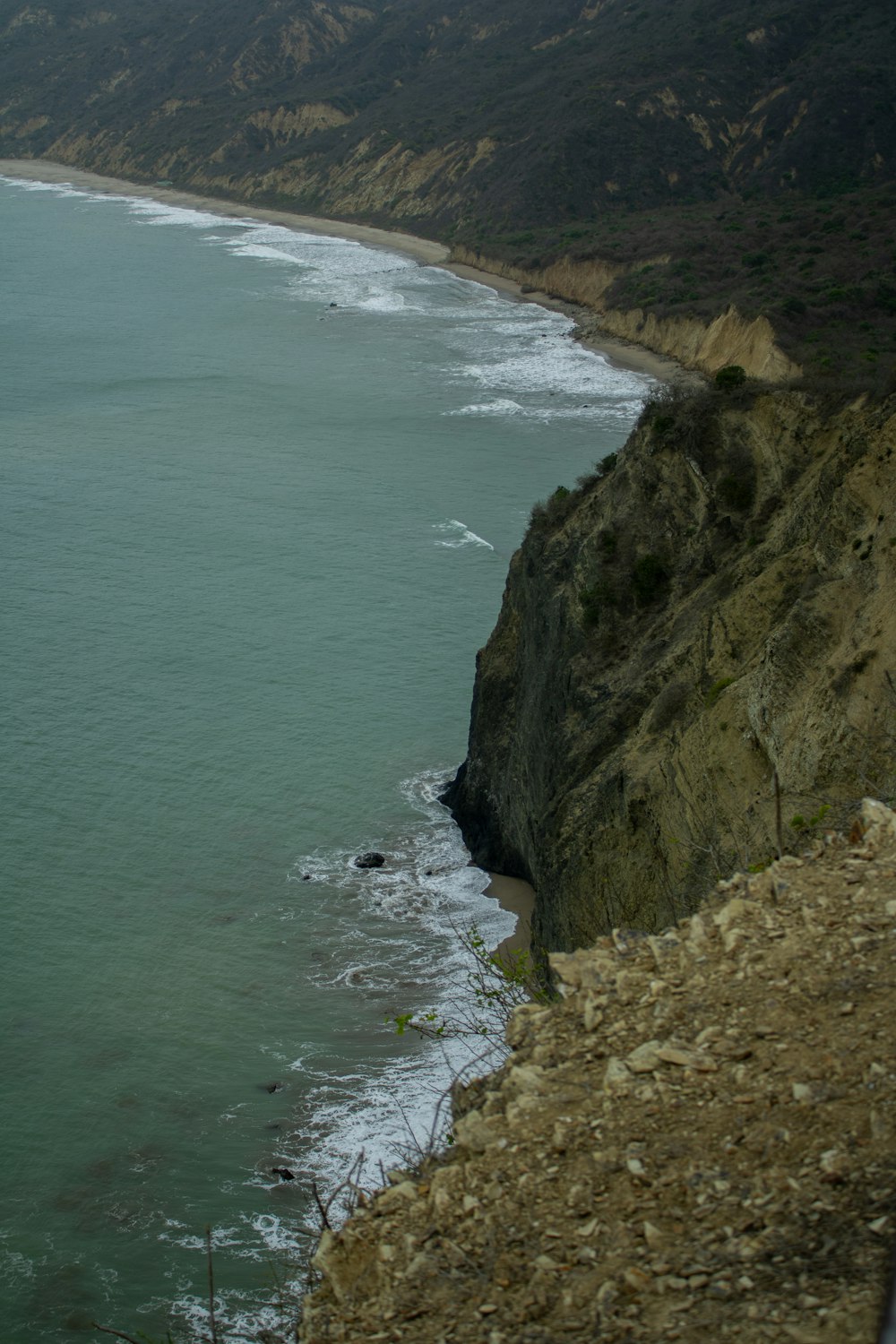 a large body of water next to a rocky cliff