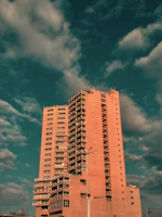 Elegant high-rise luxury apartment building at sunset with warm lighting.