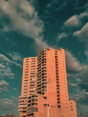 Elegant high-rise luxury apartment building at sunset with warm lighting.
