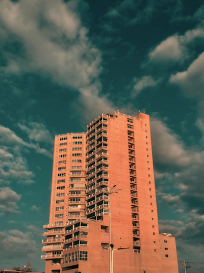 Elegant high-rise multifamily apartment building at sunset with warm lighting.