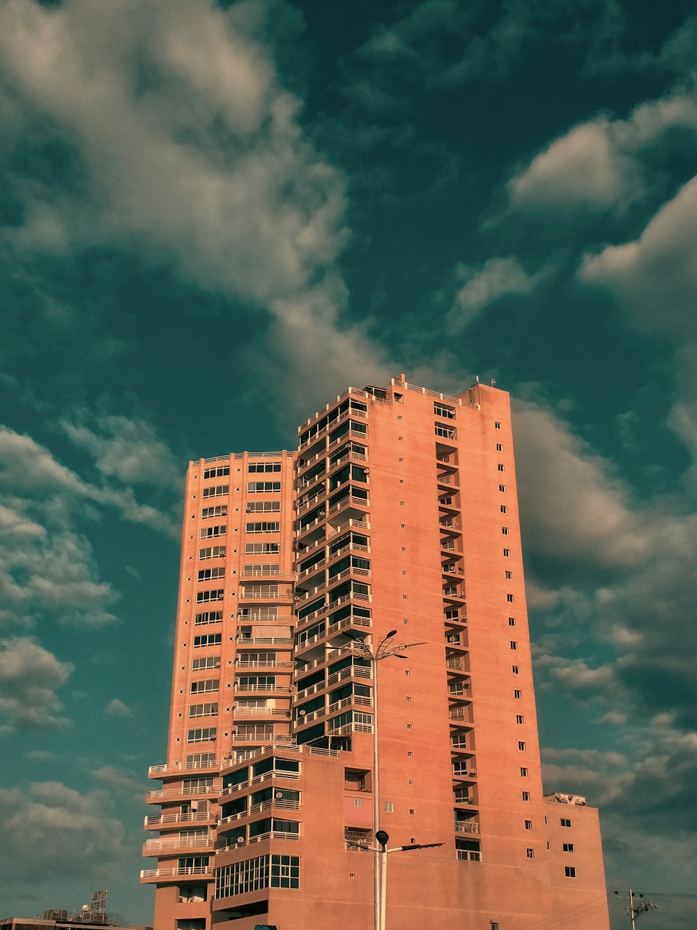 a tall building sitting under a cloudy blue sky