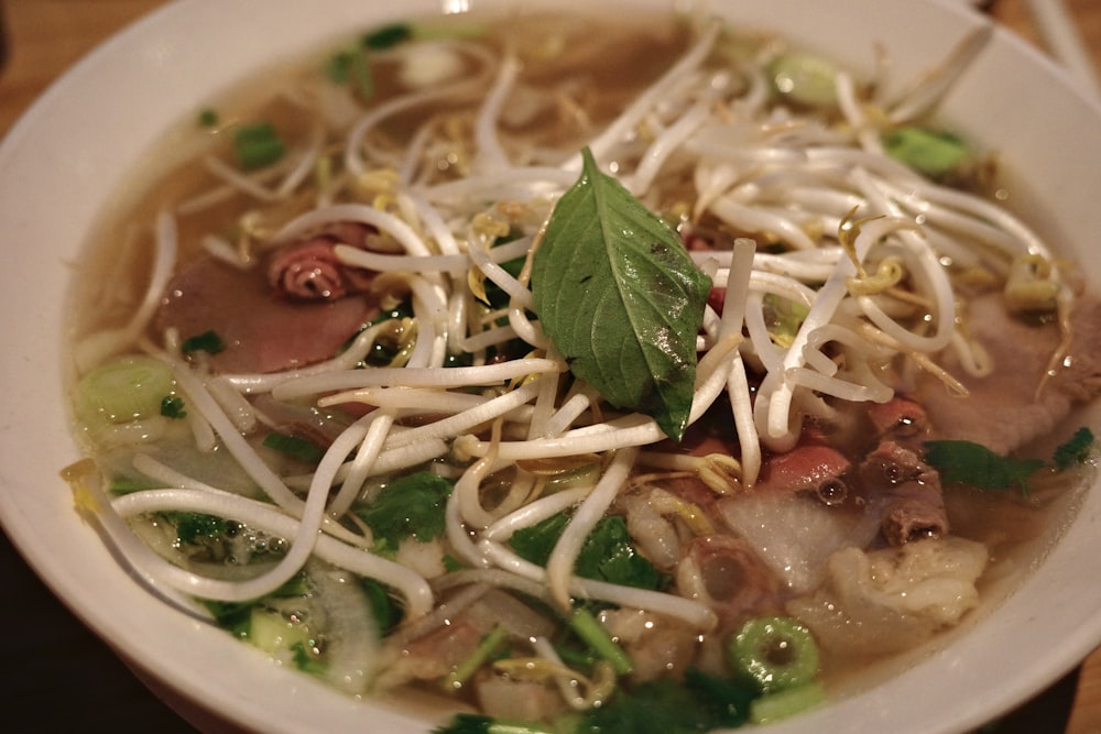 a bowl of soup with noodles, meat and vegetables