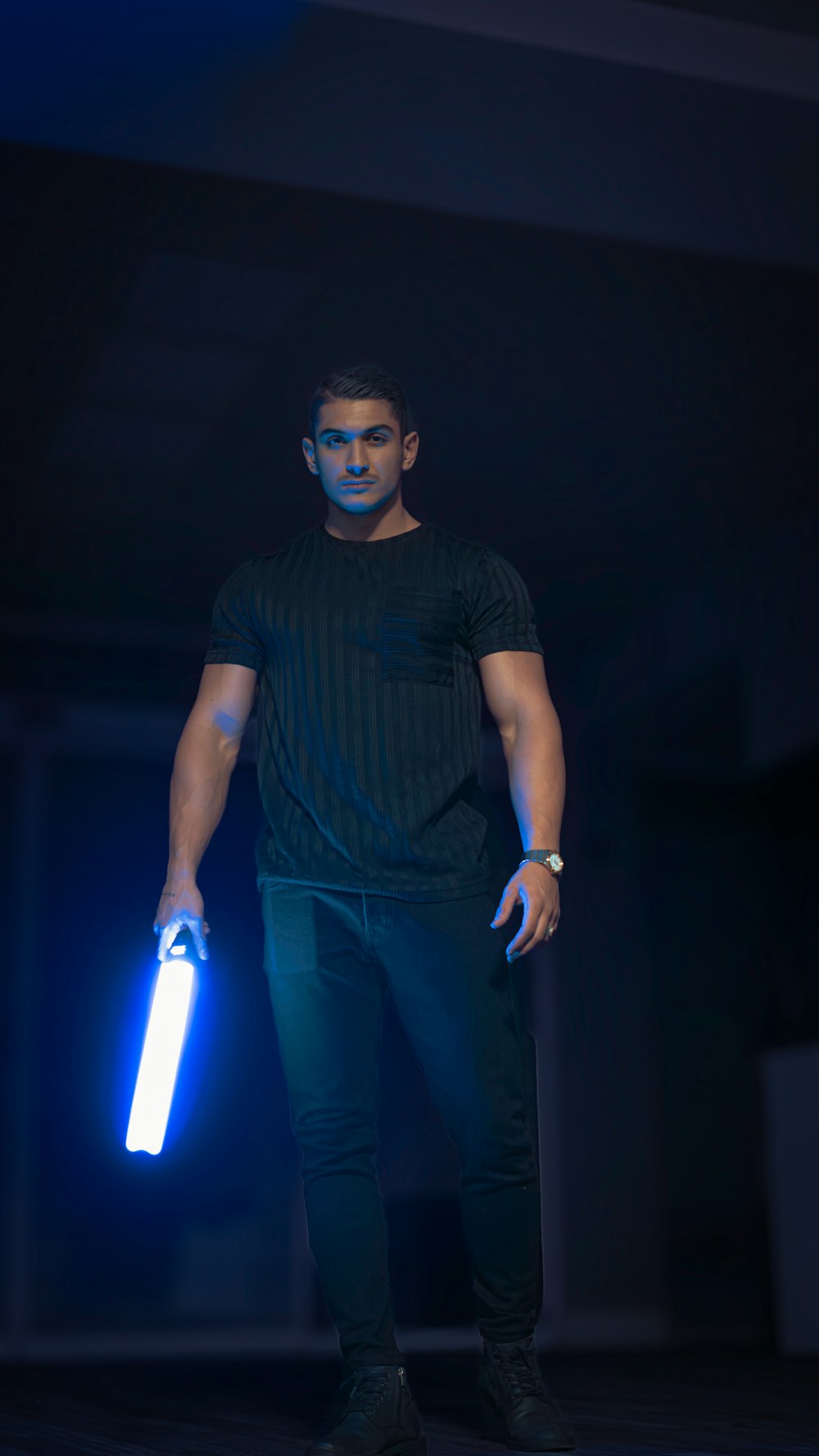 a man is holding a blue light in his hand