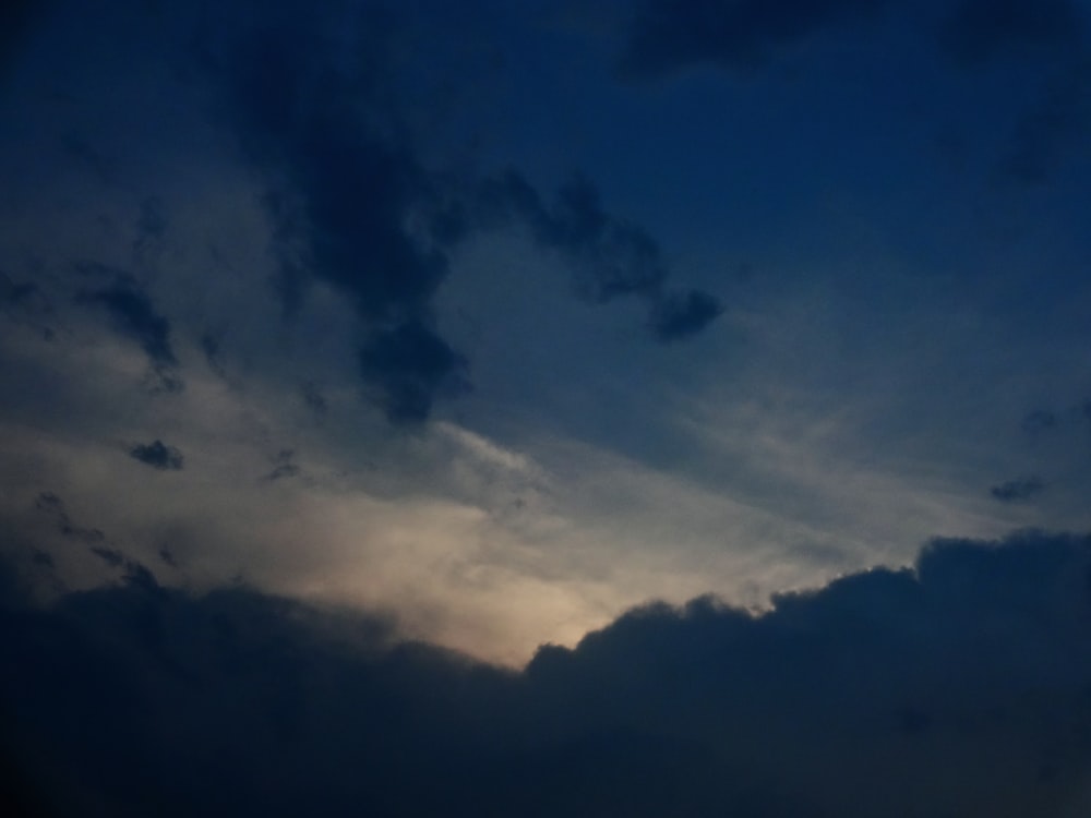 a plane flying through a cloudy sky at night