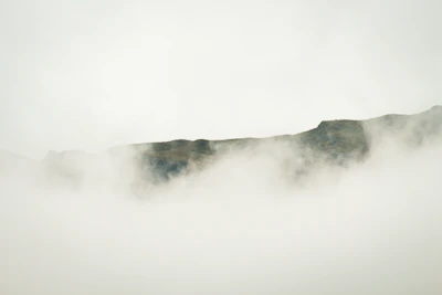 A striking, misty mountain peak barely visible through soft morning fog.
