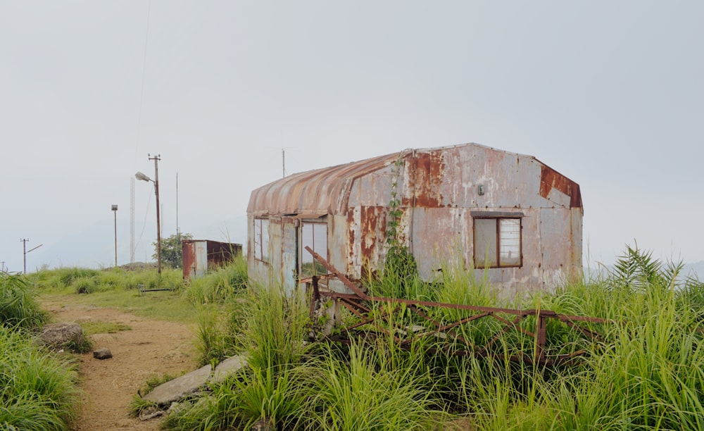 an old rusted out building in the middle of a field