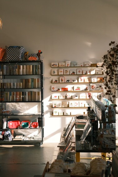 A cozy, well-organized shelf displaying a mix of daily necessities and stationery items in warm natural light.