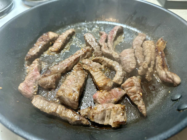 Slices of tender sirloin steak sizzling on a cast iron skillet