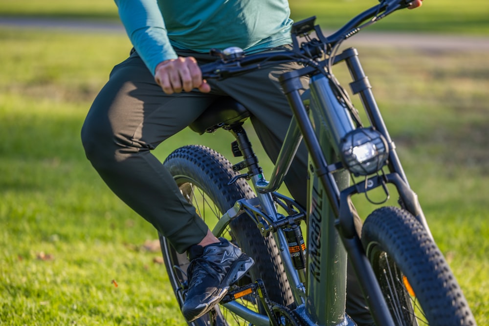 a person riding a bike on a grassy field