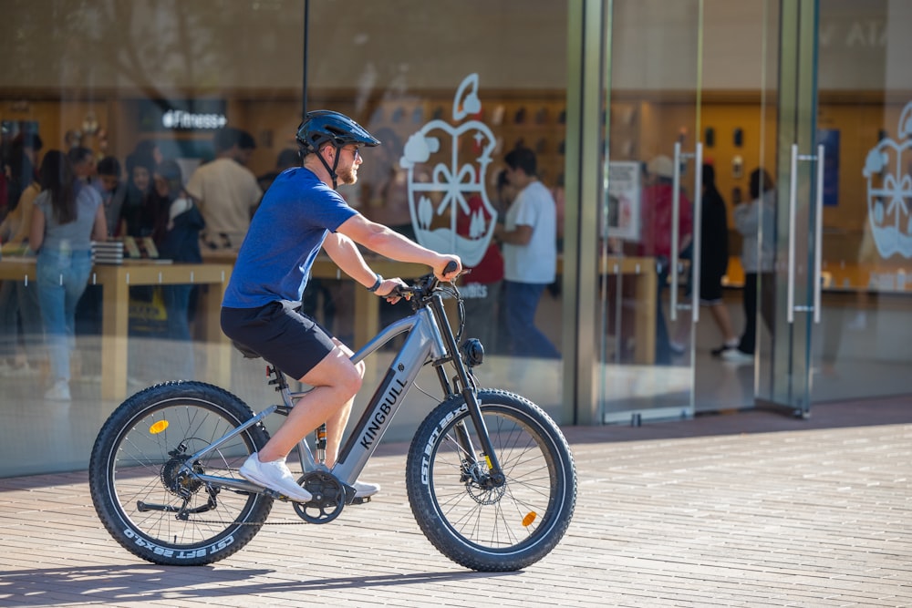 a man riding a bike in front of a store