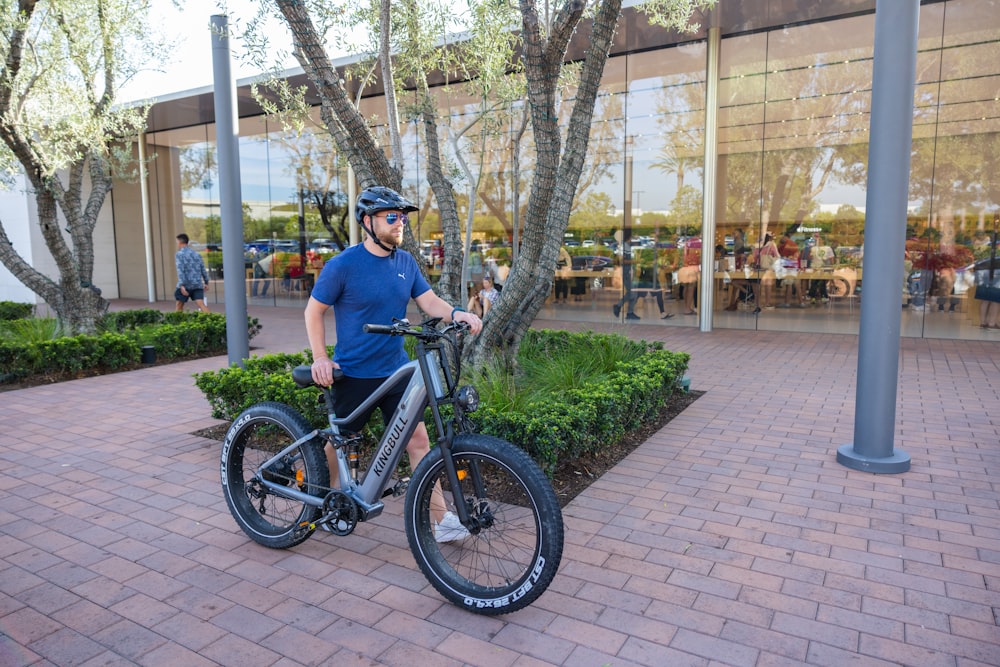 a man standing next to a bike in front of a building