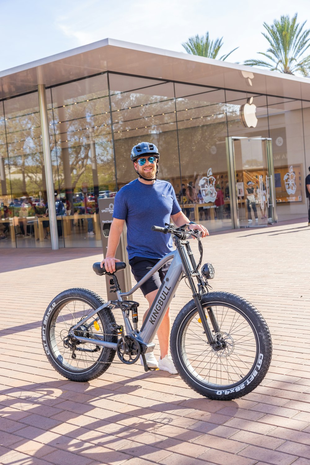 a man standing next to a bike in front of a building