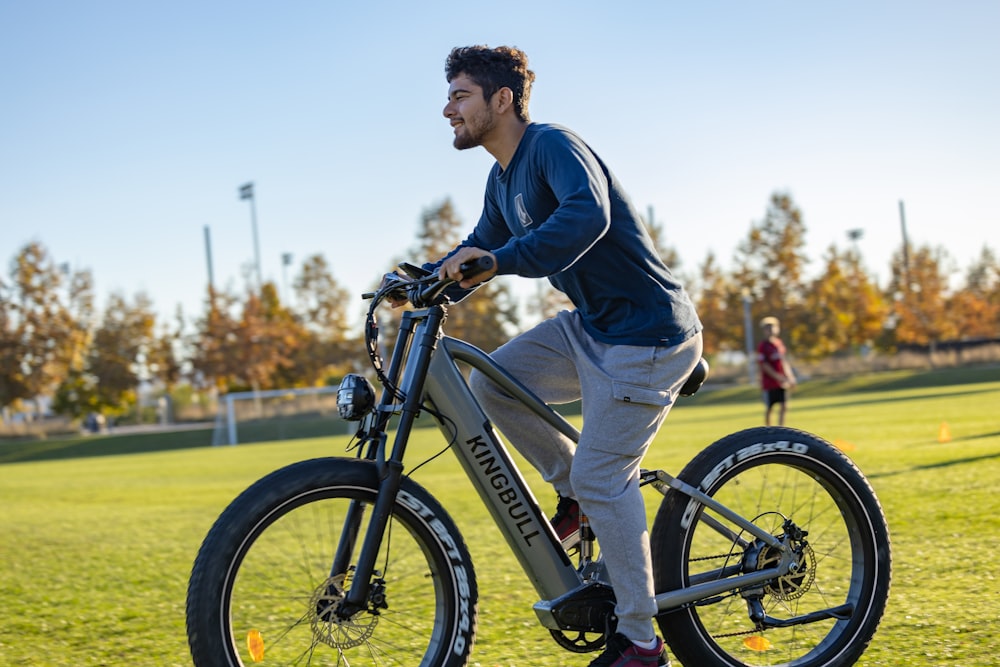 a man riding a bike on top of a lush green field