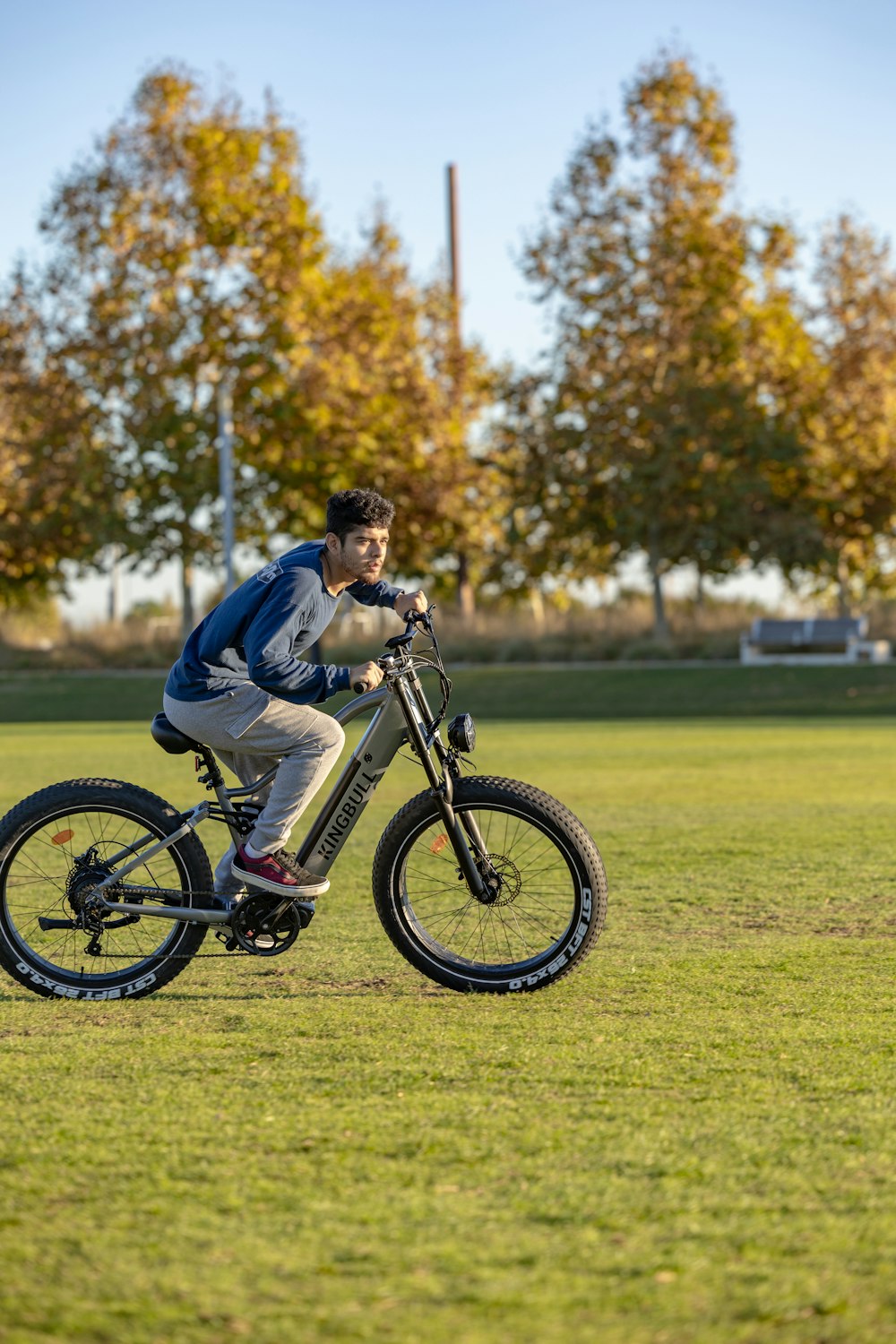 a man riding a bike on top of a lush green field