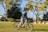 A smiling customer enjoying a ride on a colorful e-bike in a sunny park.