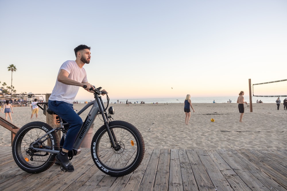 a man riding a bike on top of a wooden pier