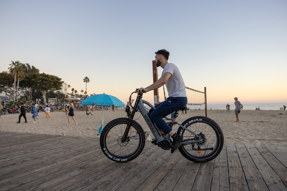 a man riding a bike on top of a wooden pier