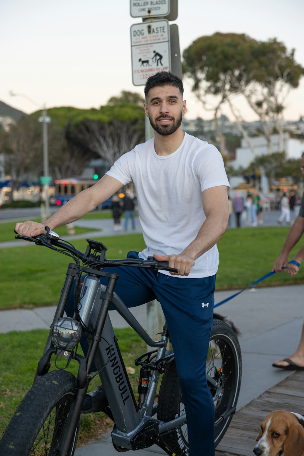 a man riding a bike with a dog on a leash