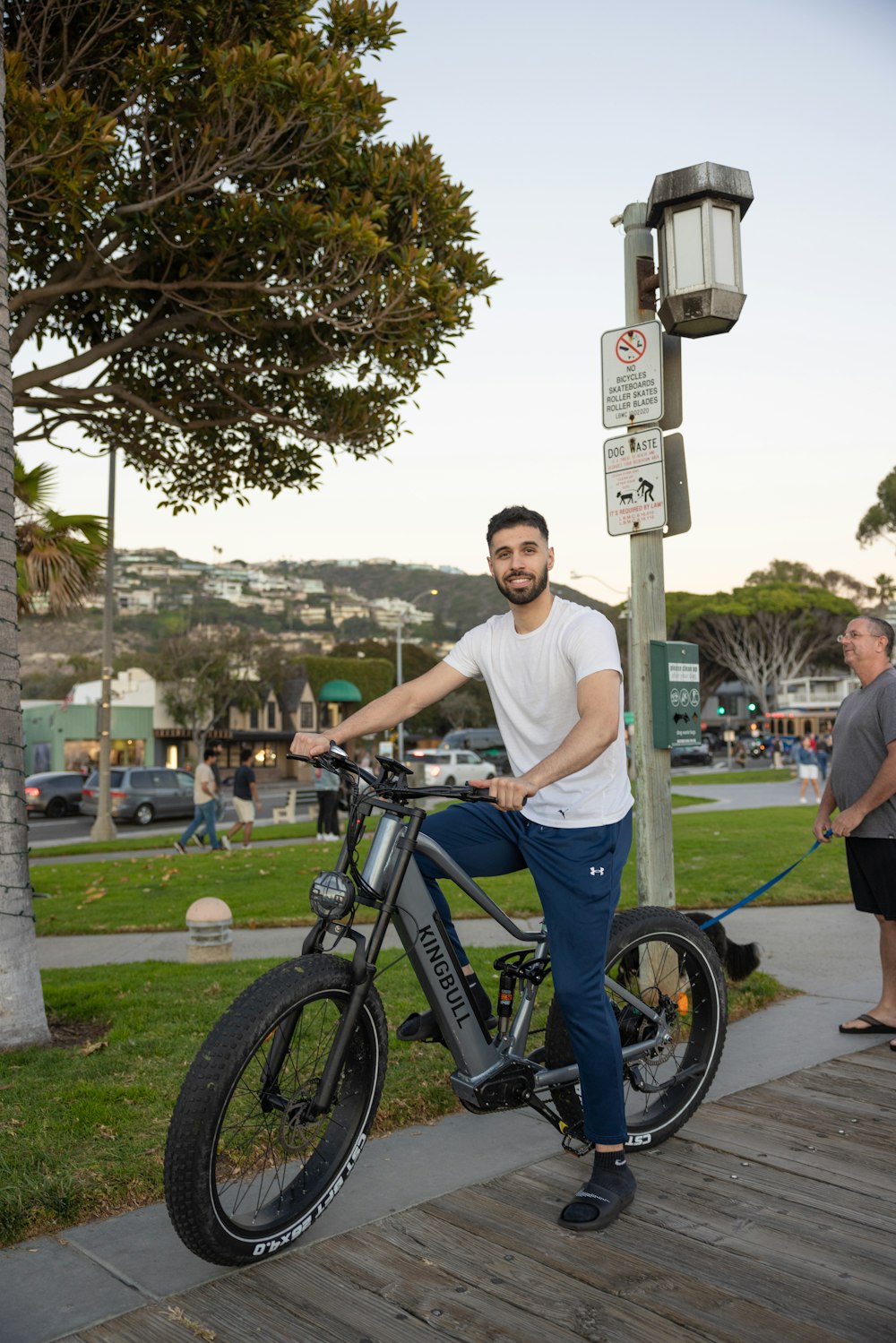 a man standing next to a bike on a sidewalk