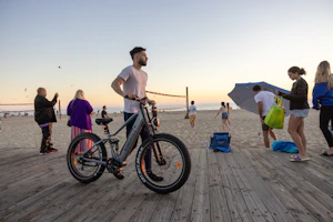 A group of friends riding colorful exploit e bikes along a coastal boardwalk, laughter in the air.