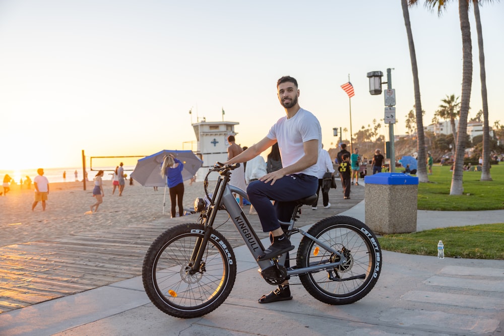 a man sitting on a bike on the beach