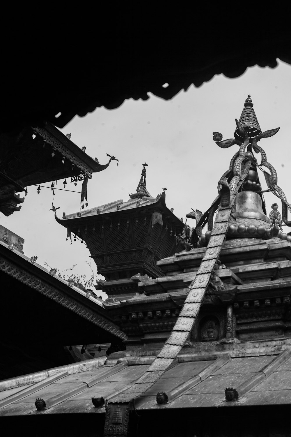 a black and white photo of a statue on top of a building