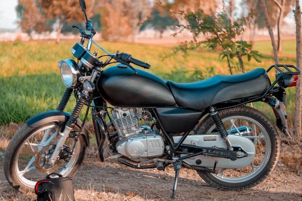ein blau-schwarzes Motorrad, das auf einem Feldweg geparkt ist