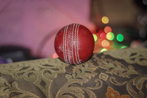 A glowing neon green and gold cricket ball spinning against a dark stadium background with shining lights.