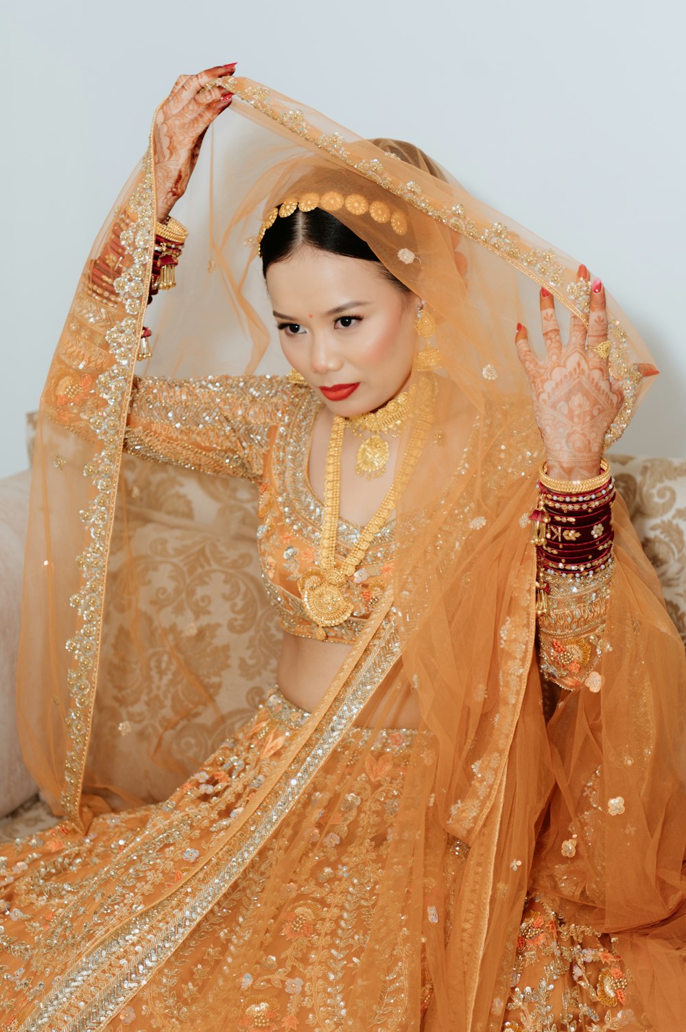 a woman wearing a veil and holding her hands up