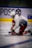 Focused athlete lacing up skates in a softly lit locker room, preparing mentally.