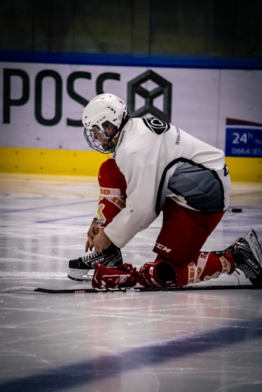 A young girl lacing up her figure skates with determination in her eyes on an outdoor rink.