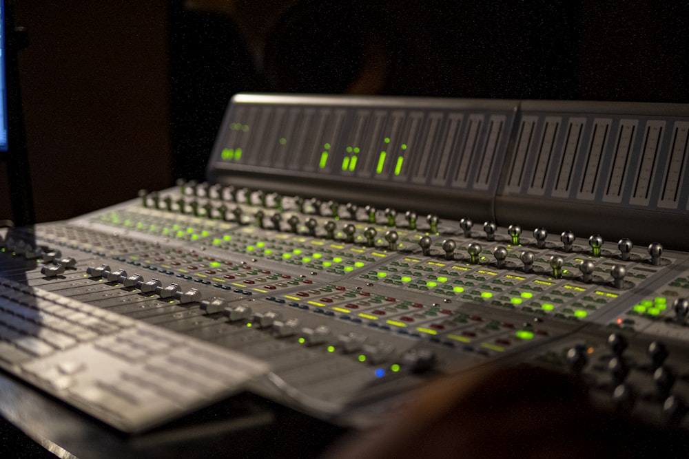 a sound board with a lot of green lights on it