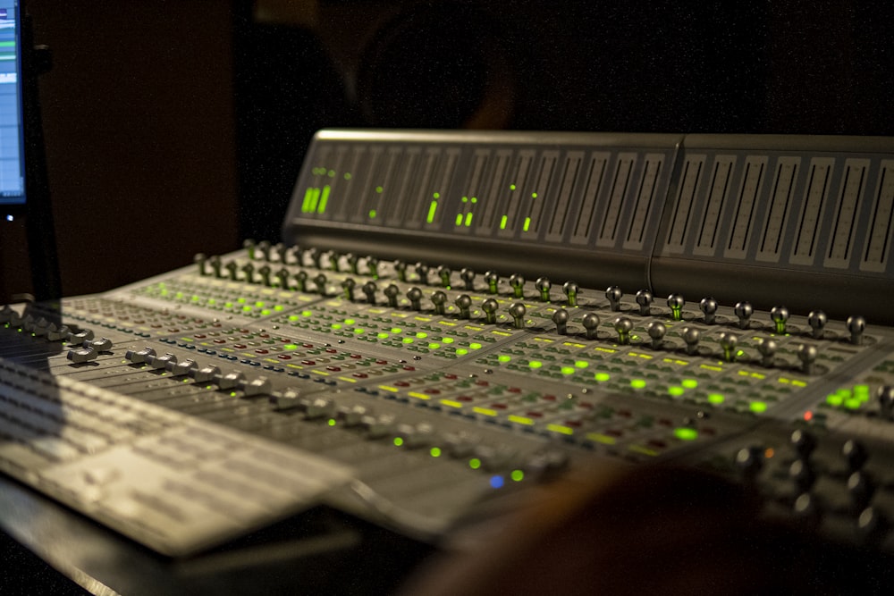 a sound mixing console with a monitor in the background