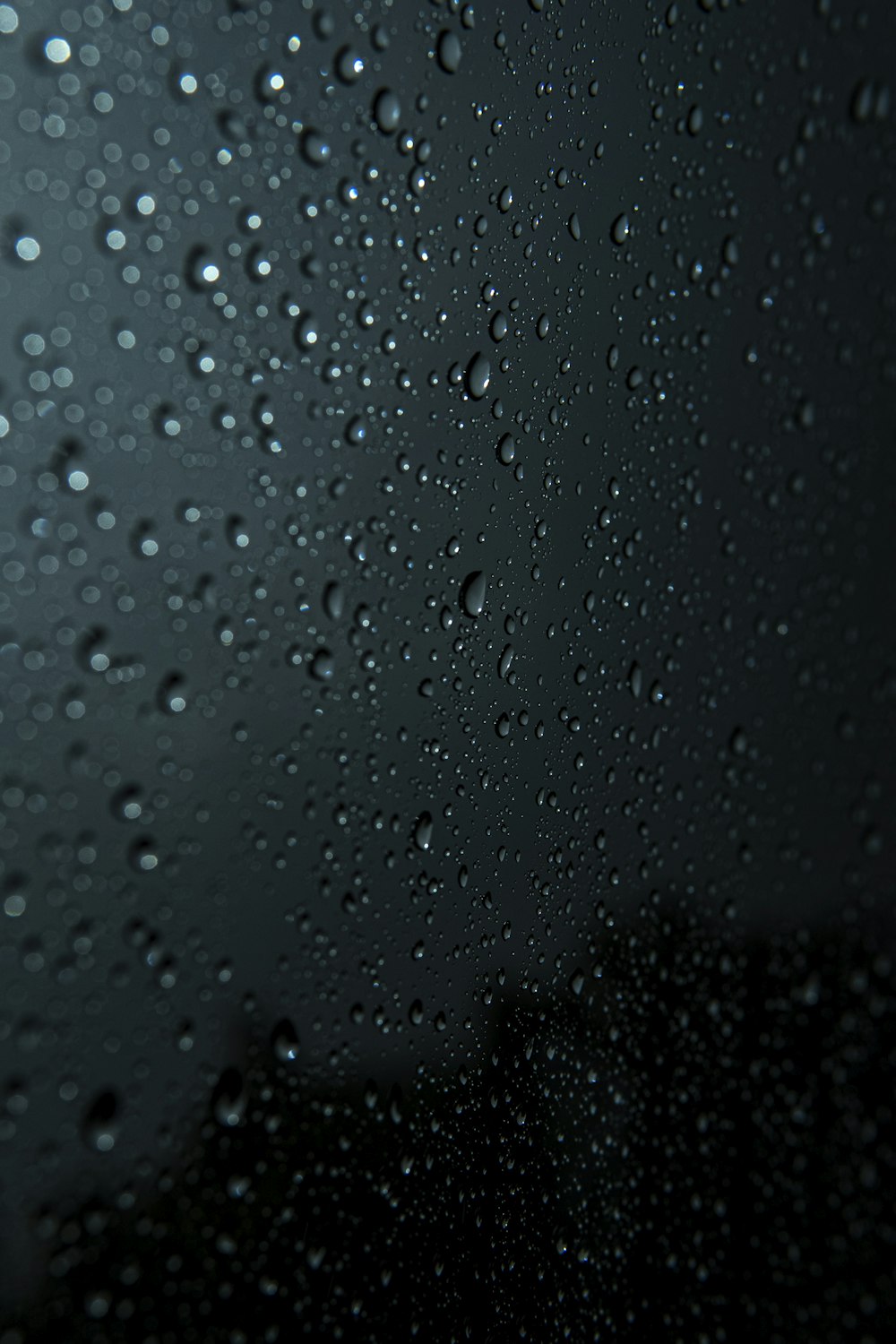 rain drops on a window with a dark background