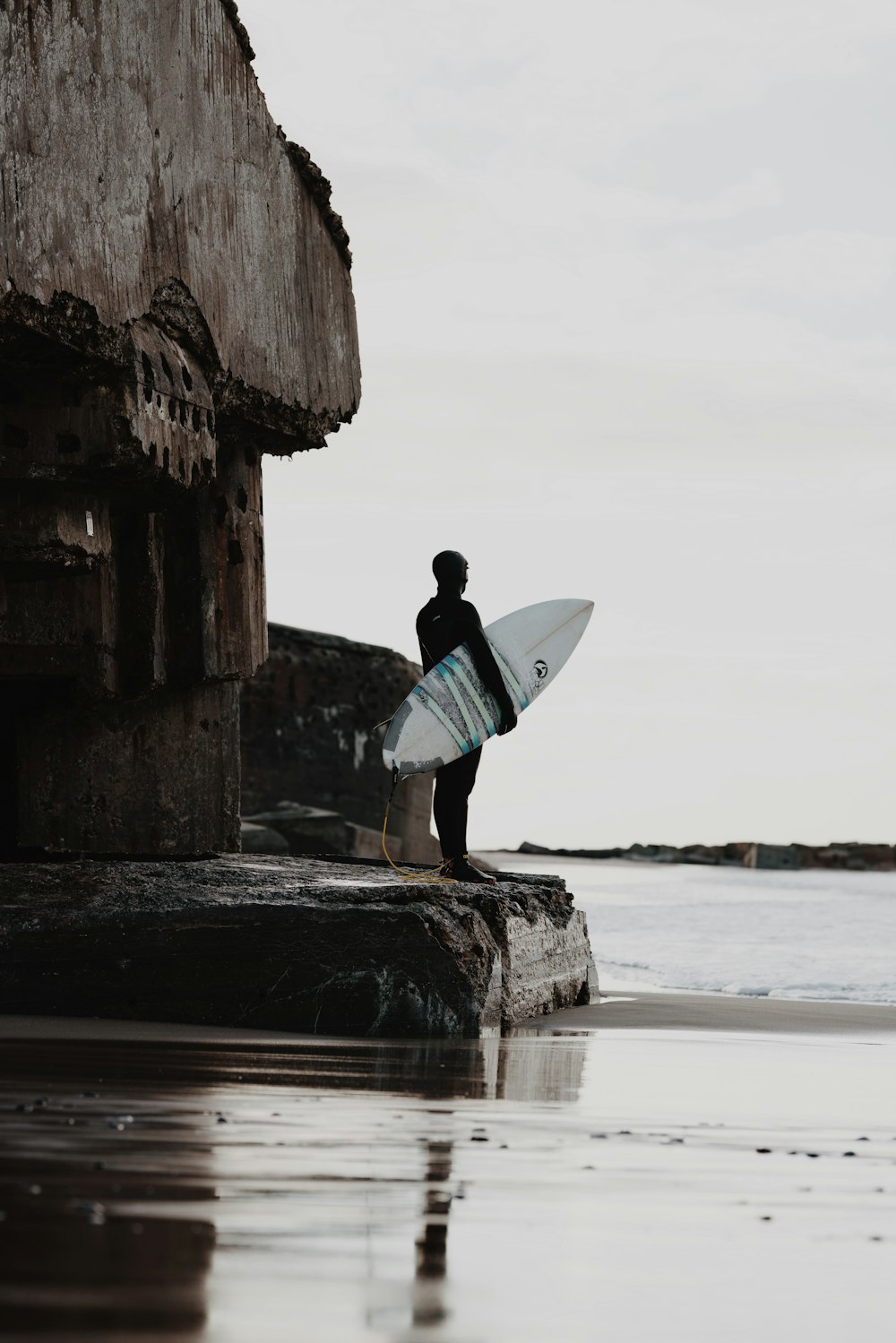 ein Mann mit einem Surfbrett auf einem Strand