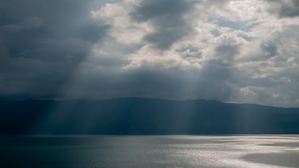 a large body of water under a cloudy sky