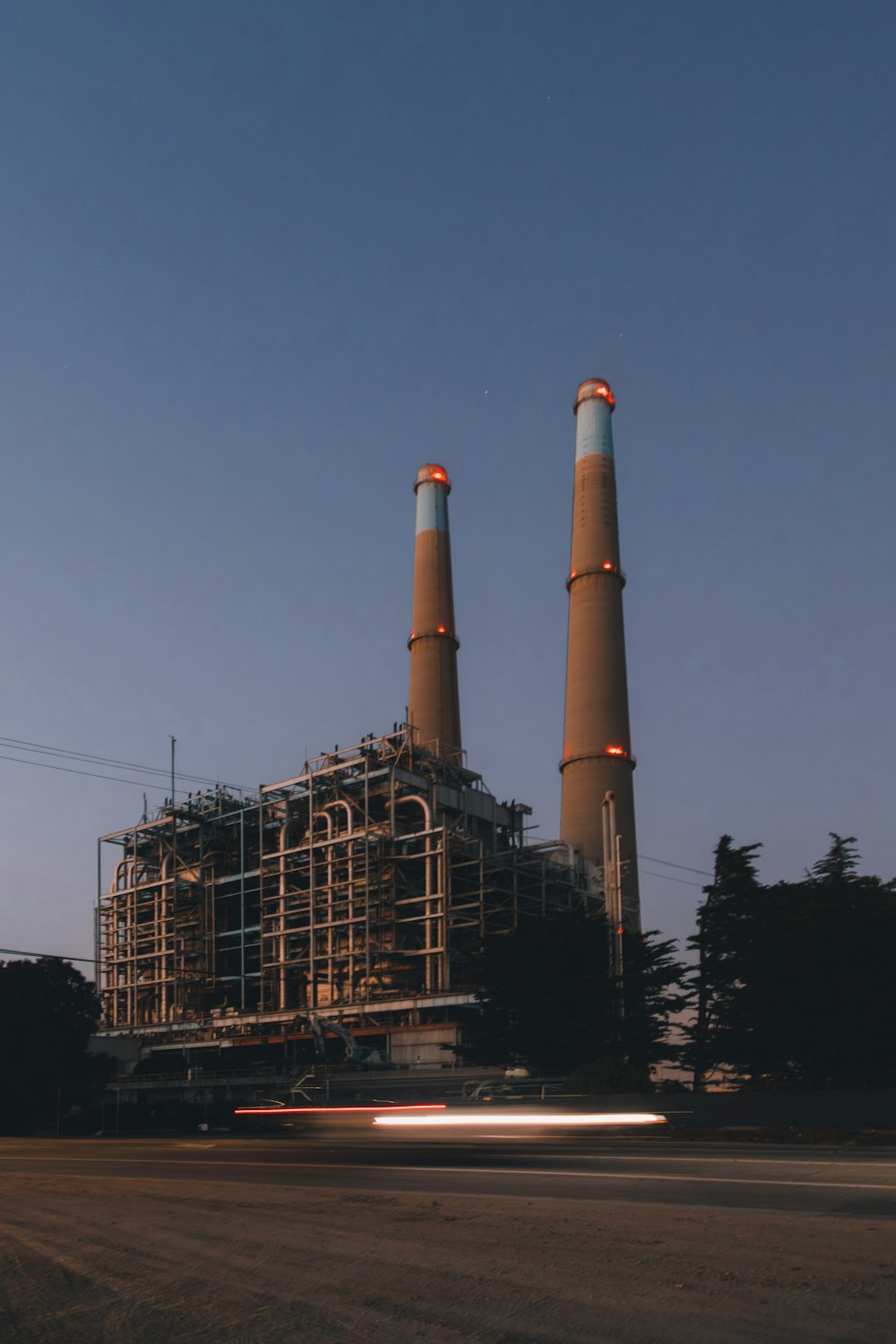 a factory with two smoke stacks in the background