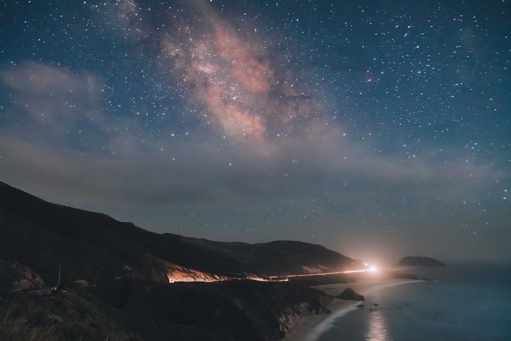 a night time view of the ocean and the stars