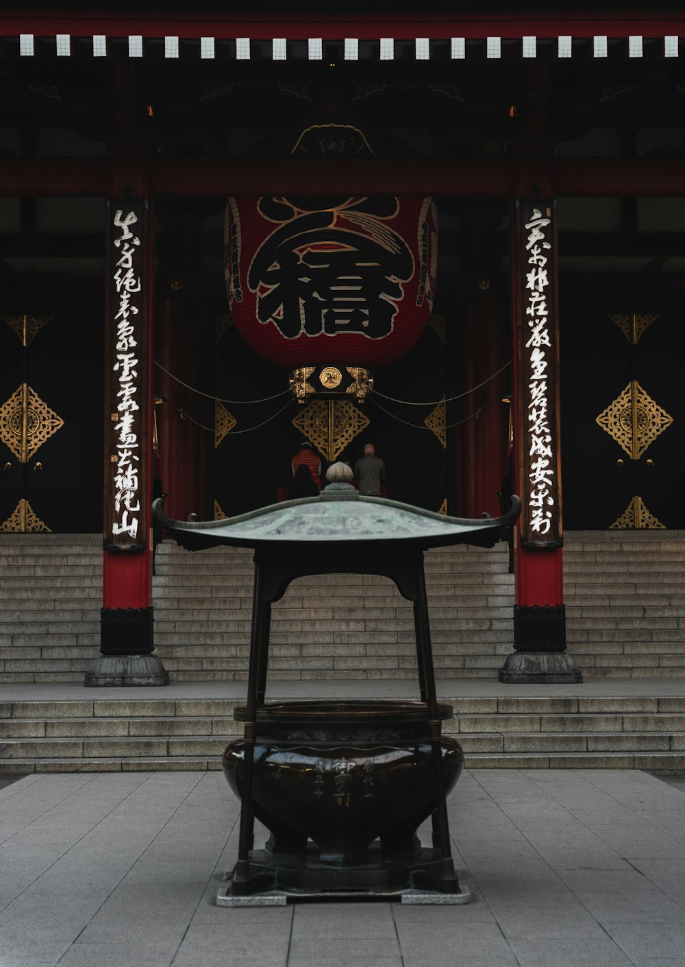 an oriental shrine with a large bell in front of it
