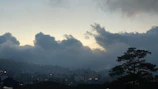 A panoramic view of a city skyline under a cloudy sky at dusk.