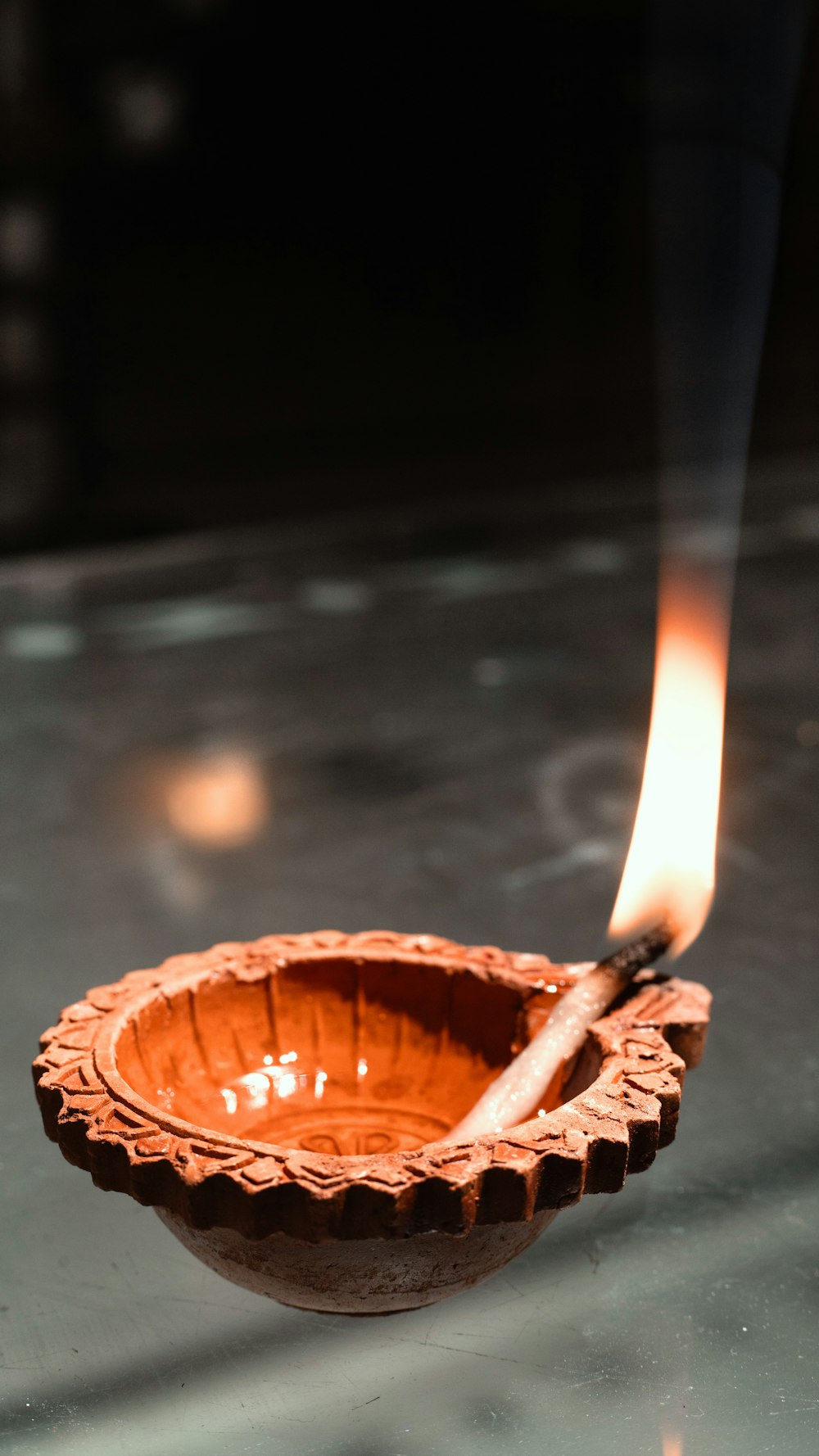 a wooden bowl with a lit matchstick sticking out of it