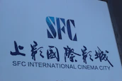 Close-up of the golden CISF Films logo illuminated against a sleek black background.